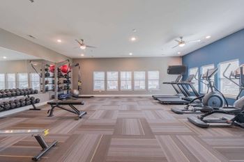 Fitness center with treadmills, ellipticals and dumbbells at Crossing at Grove City apartments in Grove City Oh